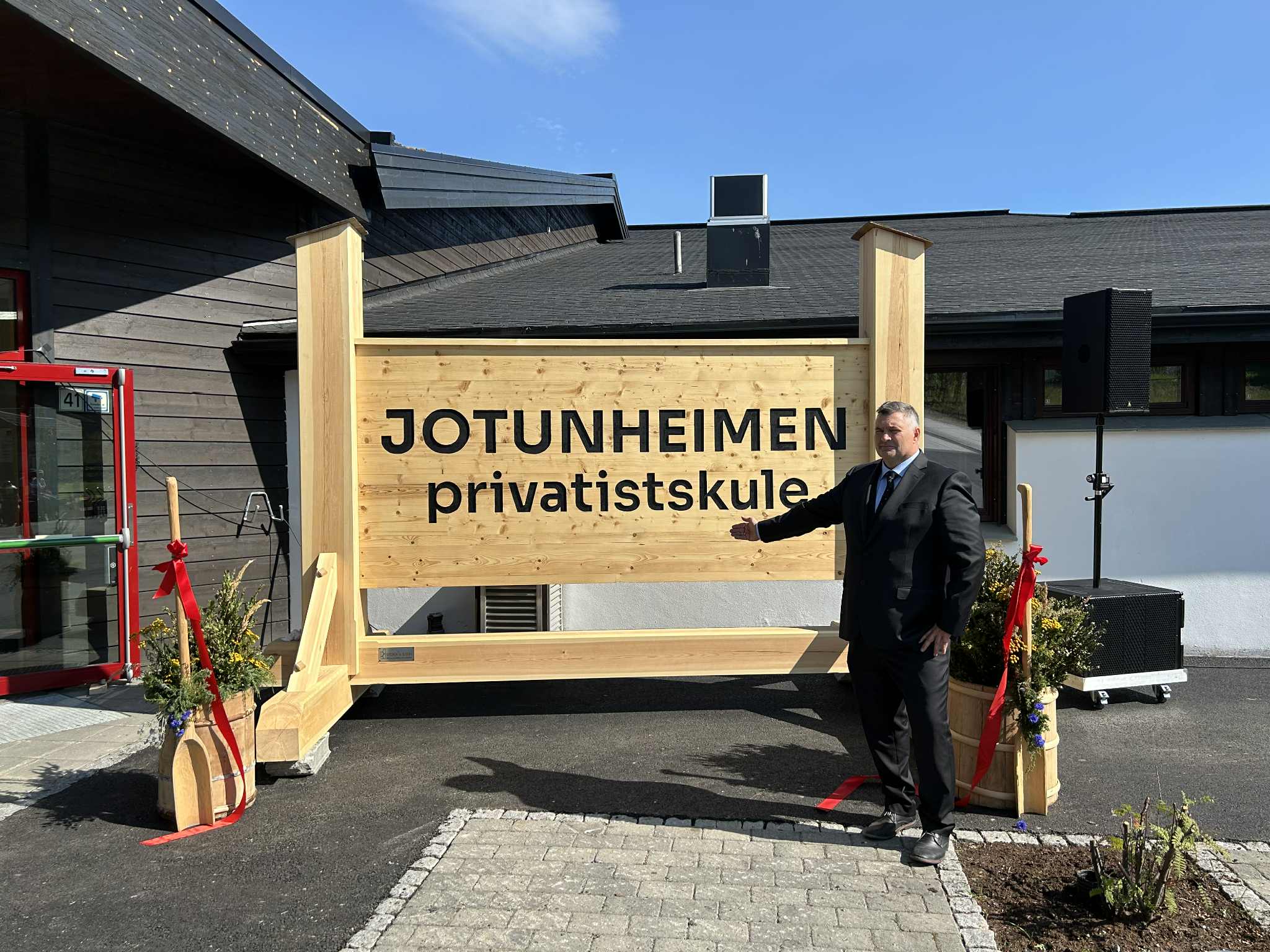 Rektor ved Jotunheimen vgs., Tor Olav Mundal, står foran tre-skilt