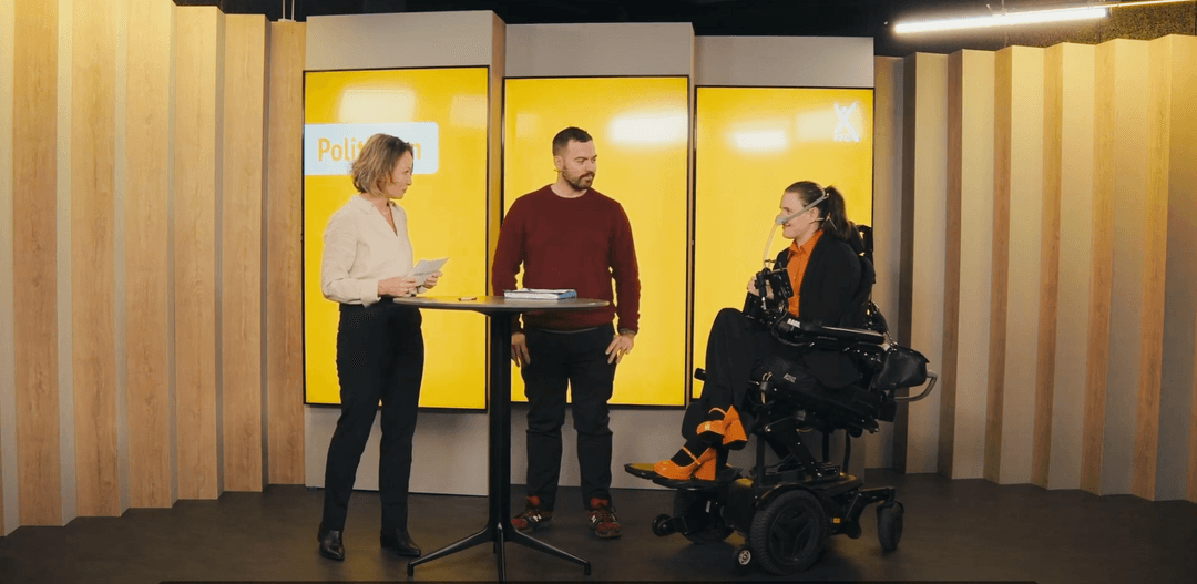 Bildet viser tre personer som står i et studio med gul bakgrunn og myk belysning.